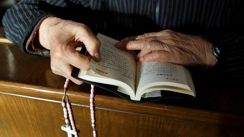 A believer reads the bible during mass at government-sanctioned St. Joseph's Church in Beijing