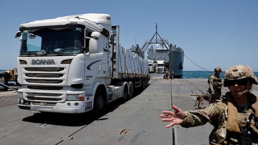 Trucks carry humanitarian aid across Trident Pier