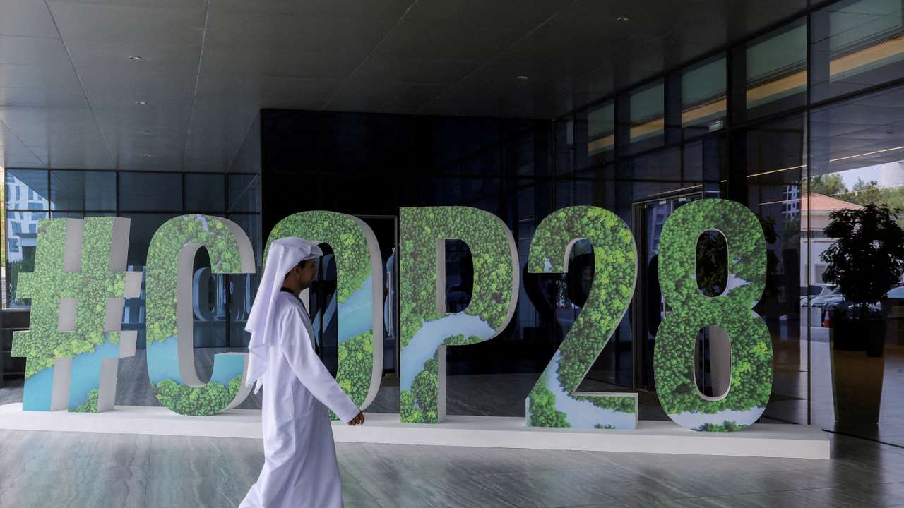 FILE PHOTO: A person walks past a "#COP28" sign during The Changemaker Majlis, a one-day CEO-level thought leadership workshop focused on climate action, in Abu Dhabi