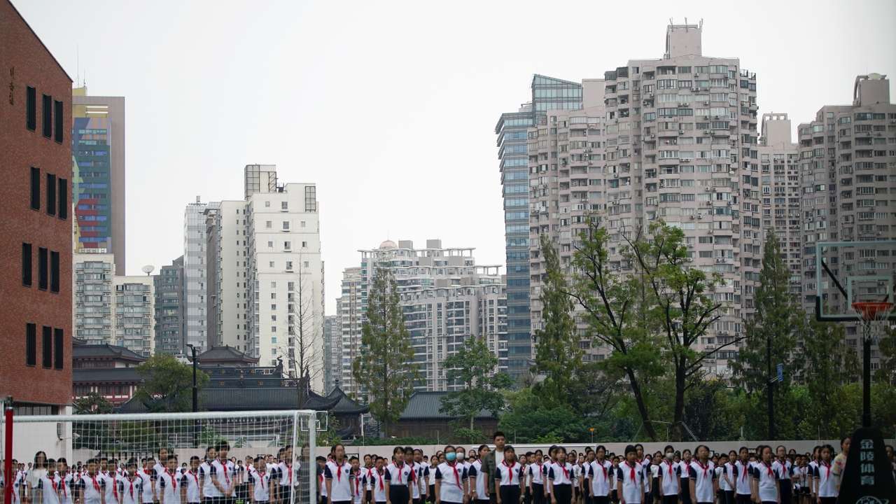 Students stand at a school on the first day of new academic year in Shanghai
