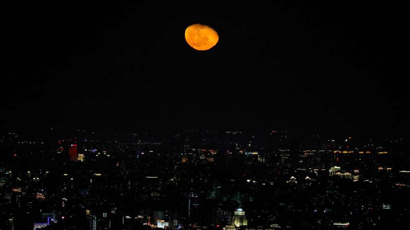 The moon is seen over the city of Beijing