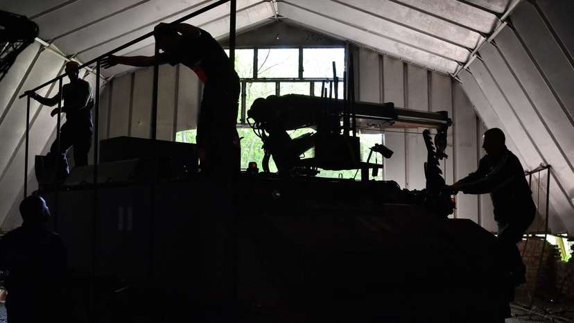 Ukrainian servisemen install an anti-drone protection to an armored repair and recovery vehicle in Zaporizhzhia region