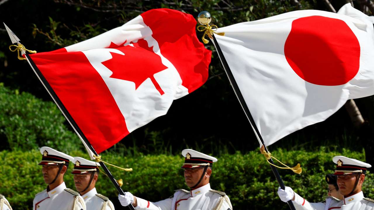 Japanese honour guards hold the national flags of Canada and Japan during a ceremony for Canadian Defence Minister Bill Blair at the Ministry of Defense in Tokyo
