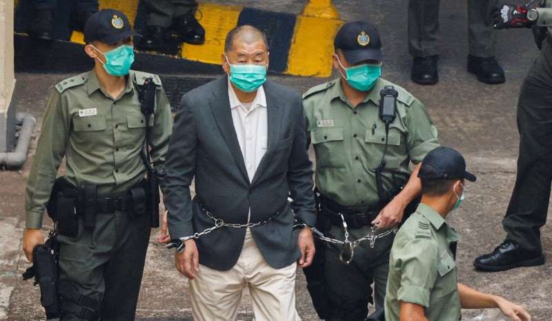 FILE PHOTO: Media mogul Jimmy Lai Chee-ying, founder of Apple Daily, walks to a prison van to head to court, after being charged under the national security law, in Hong Kong