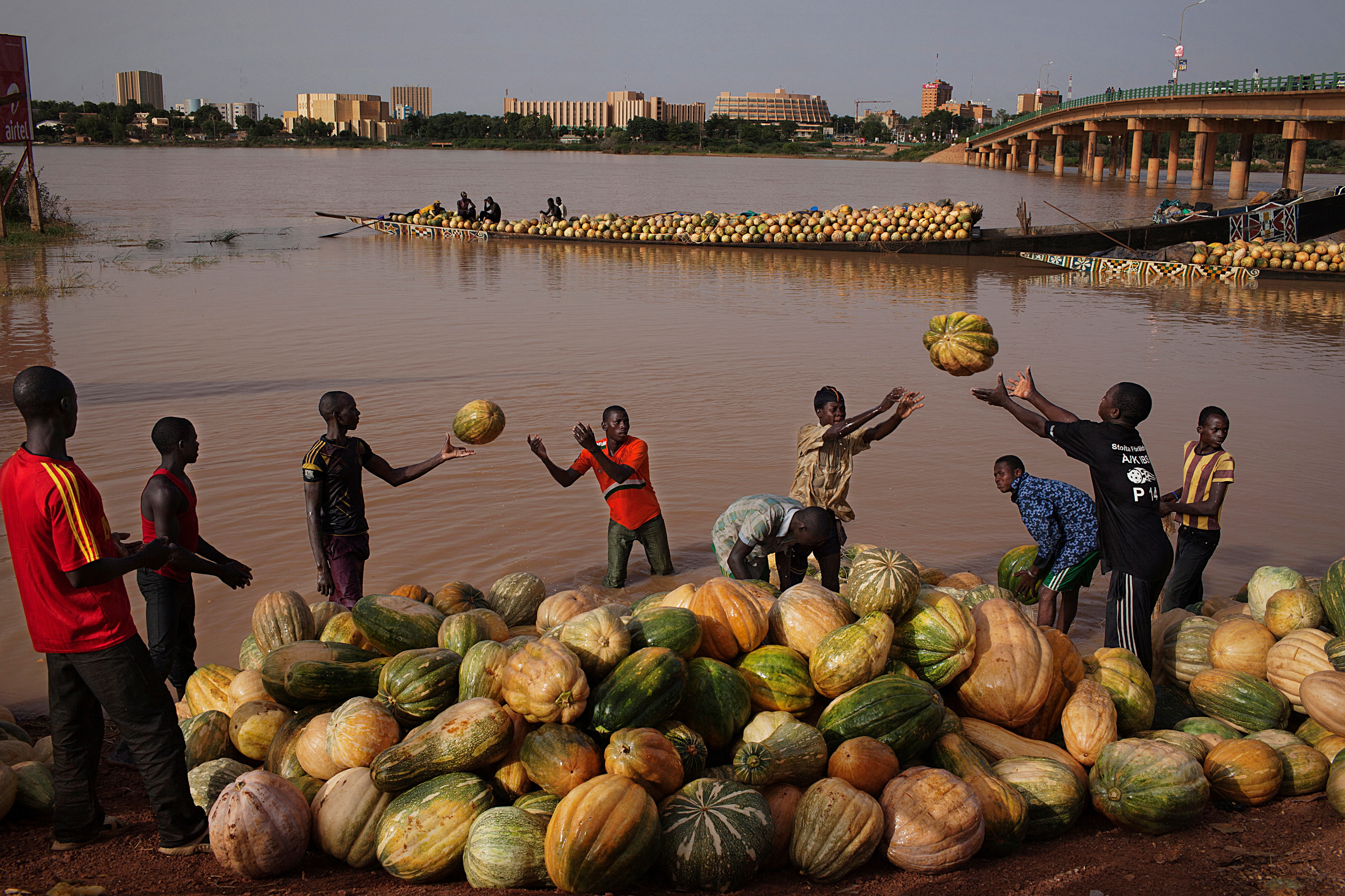 FILE PHOTO: Men toss squash onto the banks of the Niger River in Niamey
