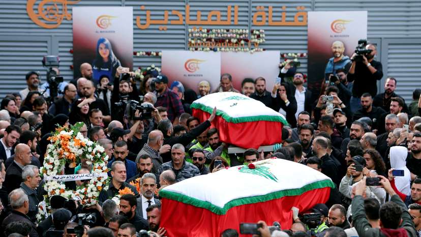 Mourners stand near the coffins of the two journalists working for Lebanon-based Al Mayadeen TV channel, in Beirut