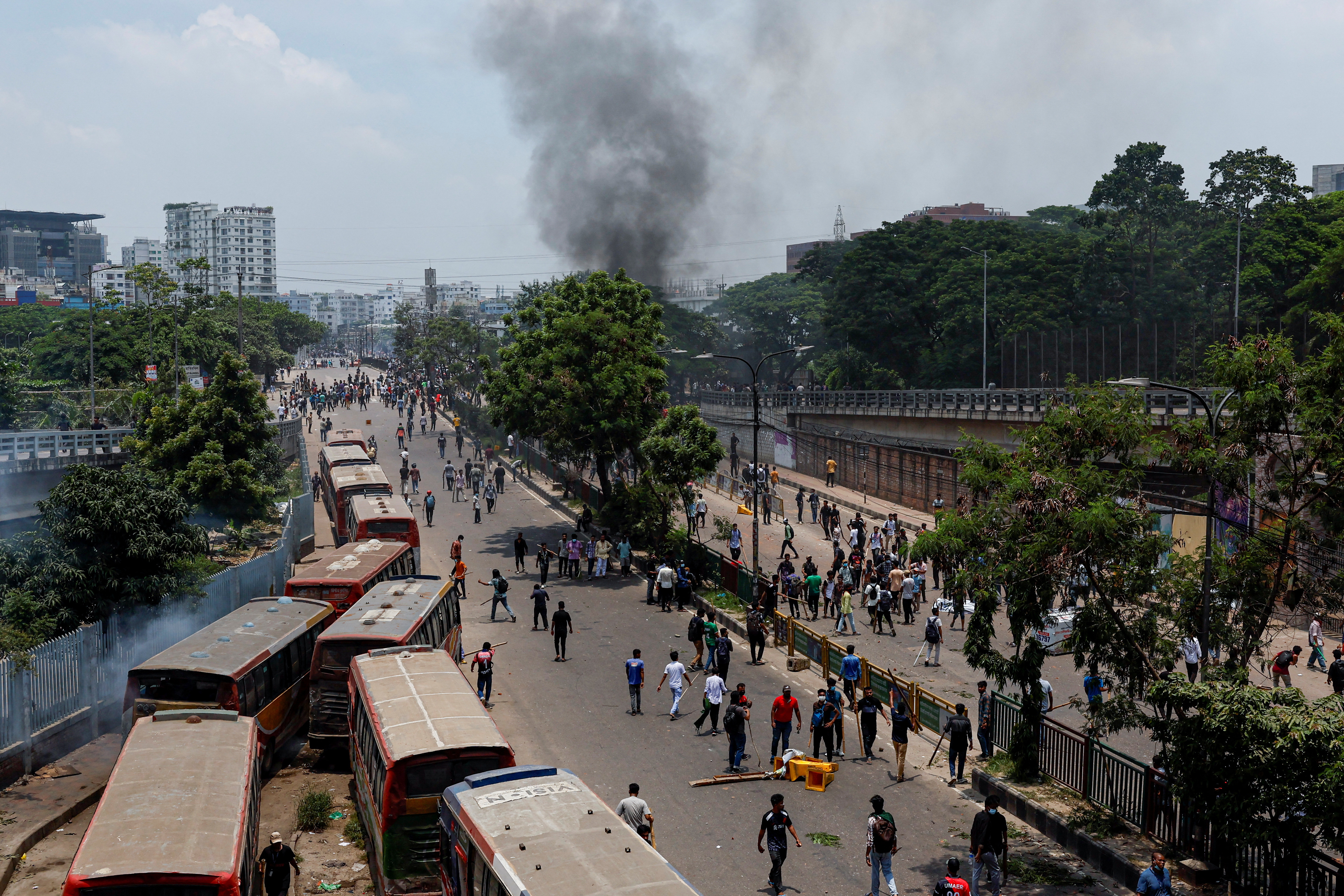 Smoke rises as anti-quota supporters clash with police and Awami League supporters at the Rampura area in Dhaka
