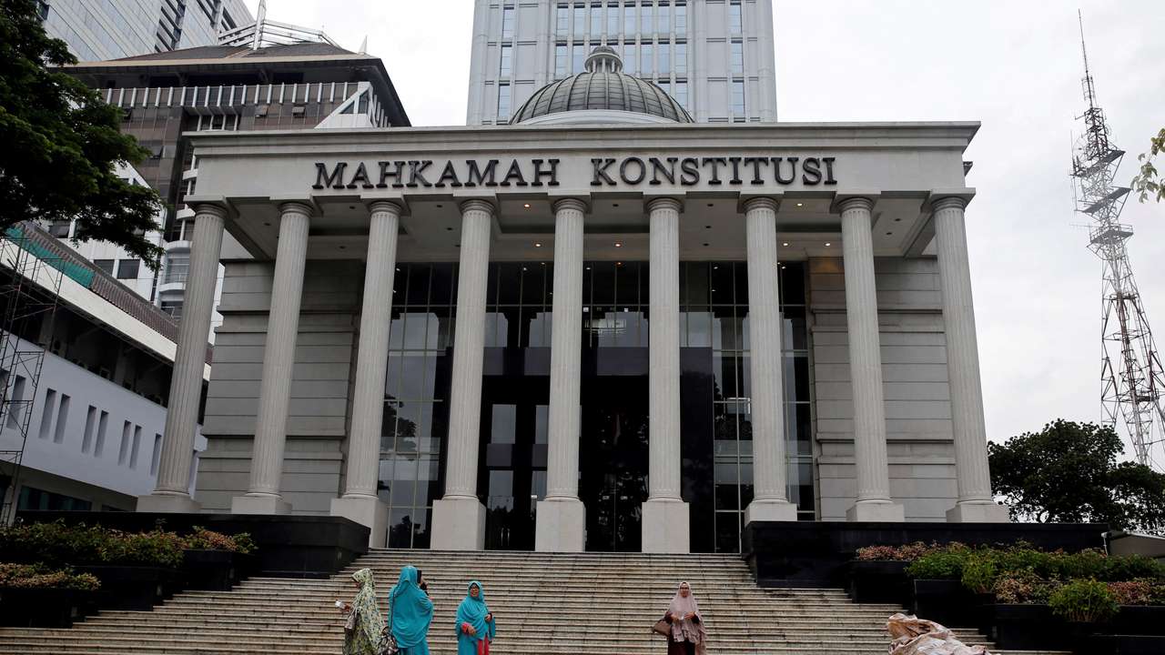 FILE PHOTO: Muslim women walk in front of Indonesia's constitutional court after attending a trial in Jakarta
