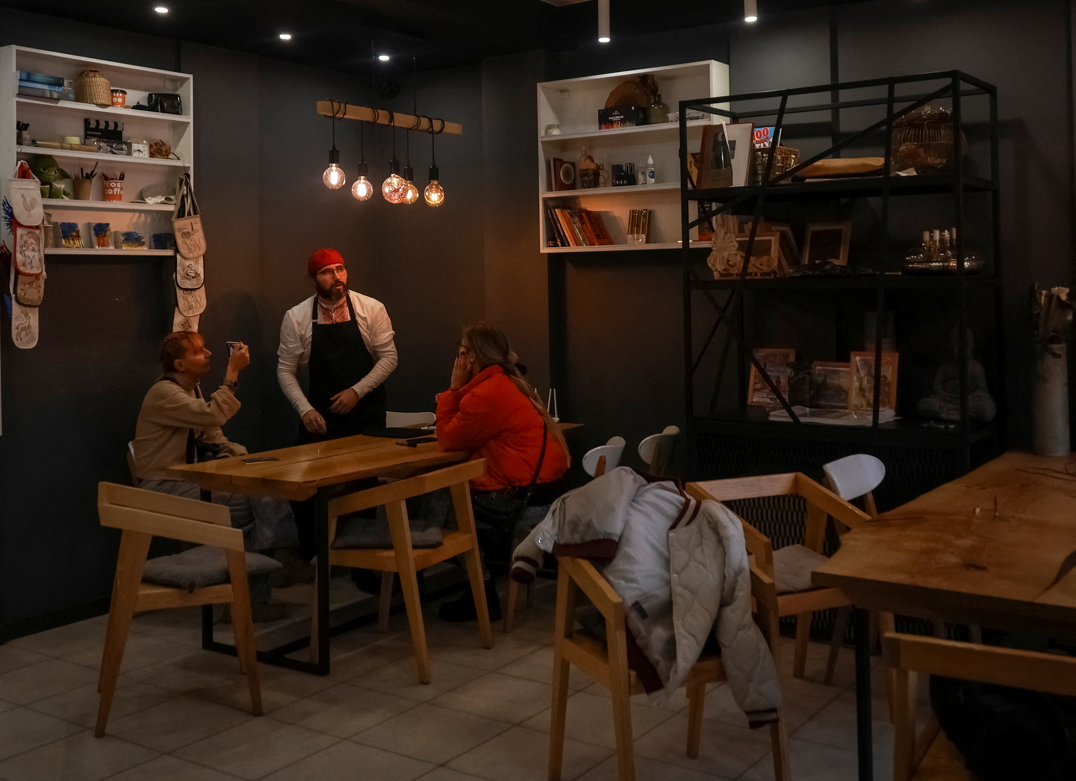 Cafe manager Melnychenko speaks with visitors in his cafe in Kherson