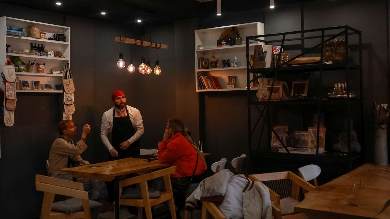Cafe manager Melnychenko speaks with visitors in his cafe in Kherson