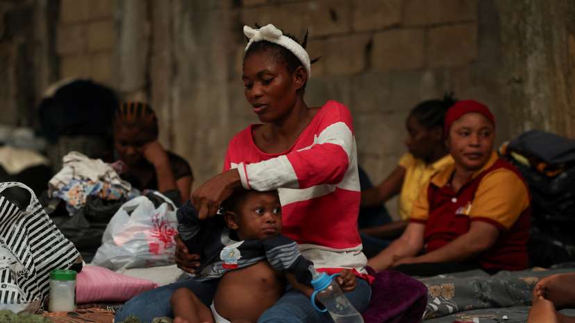 Mariatu Swarray, from Sierra Leone, dresses her one-year-old son at a shelter for displaced migrant workers, in Hazmieh