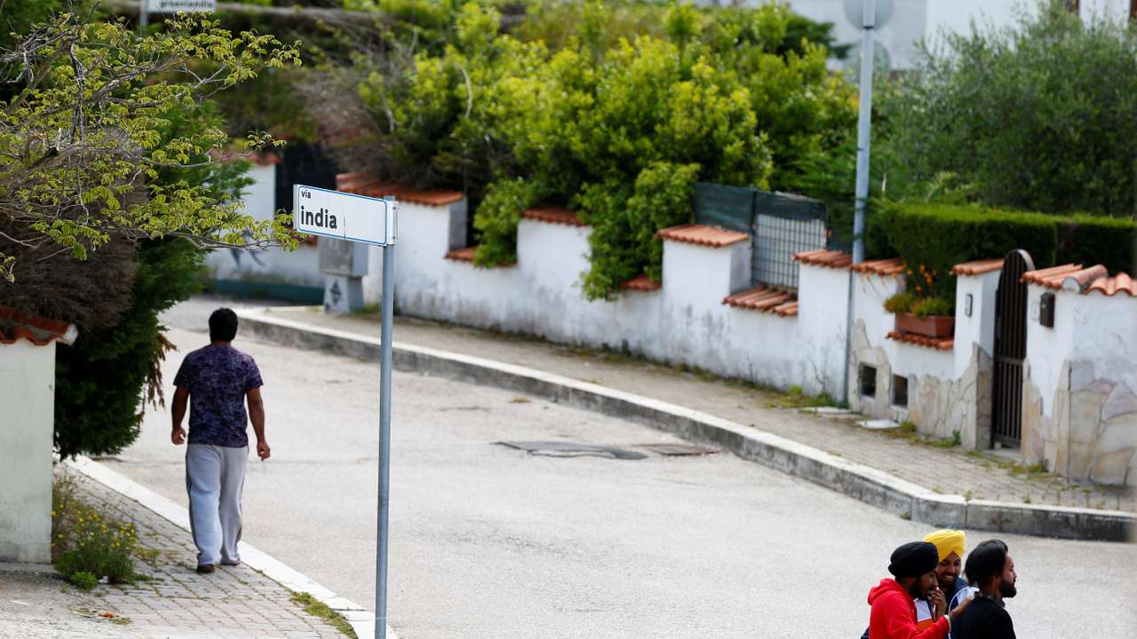 FILE PHOTO: Young Sikh migrant workers walk on a street of Bella Farnia, in the Pontine Marshes, south of Rome