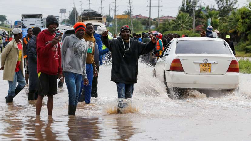 Volunteers direct traffic to clear the Athi River-Namanga highway that was affected after a seasonal river burst its banks following heavy rainfall in Kitengela municipality of Kajiado County