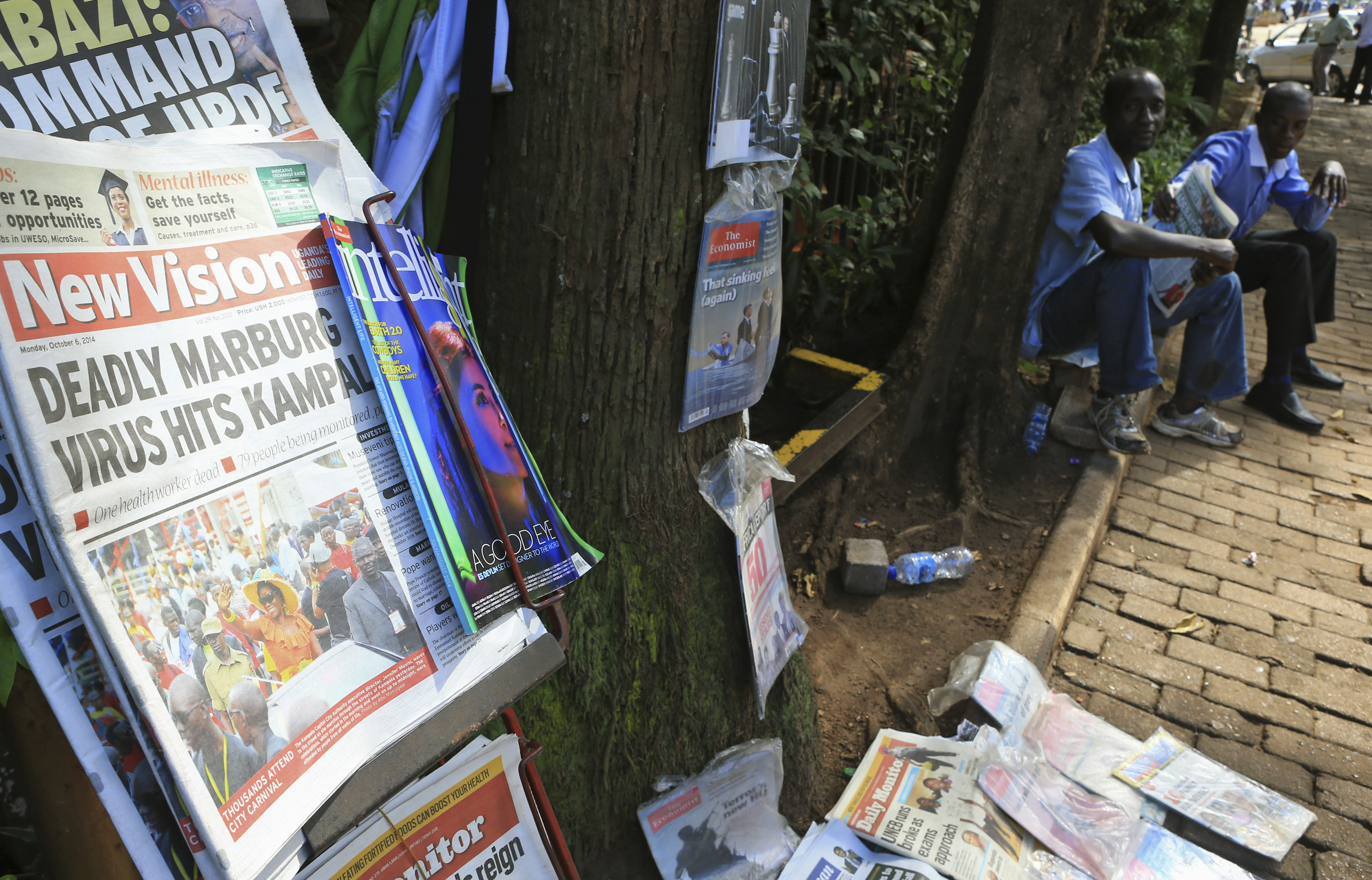 A newspaper displayed on a stand shows a headline of the Marburg virus outbreak in Kampala