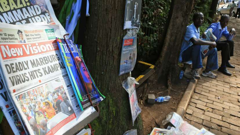 A newspaper displayed on a stand shows a headline of the Marburg virus outbreak in Kampala