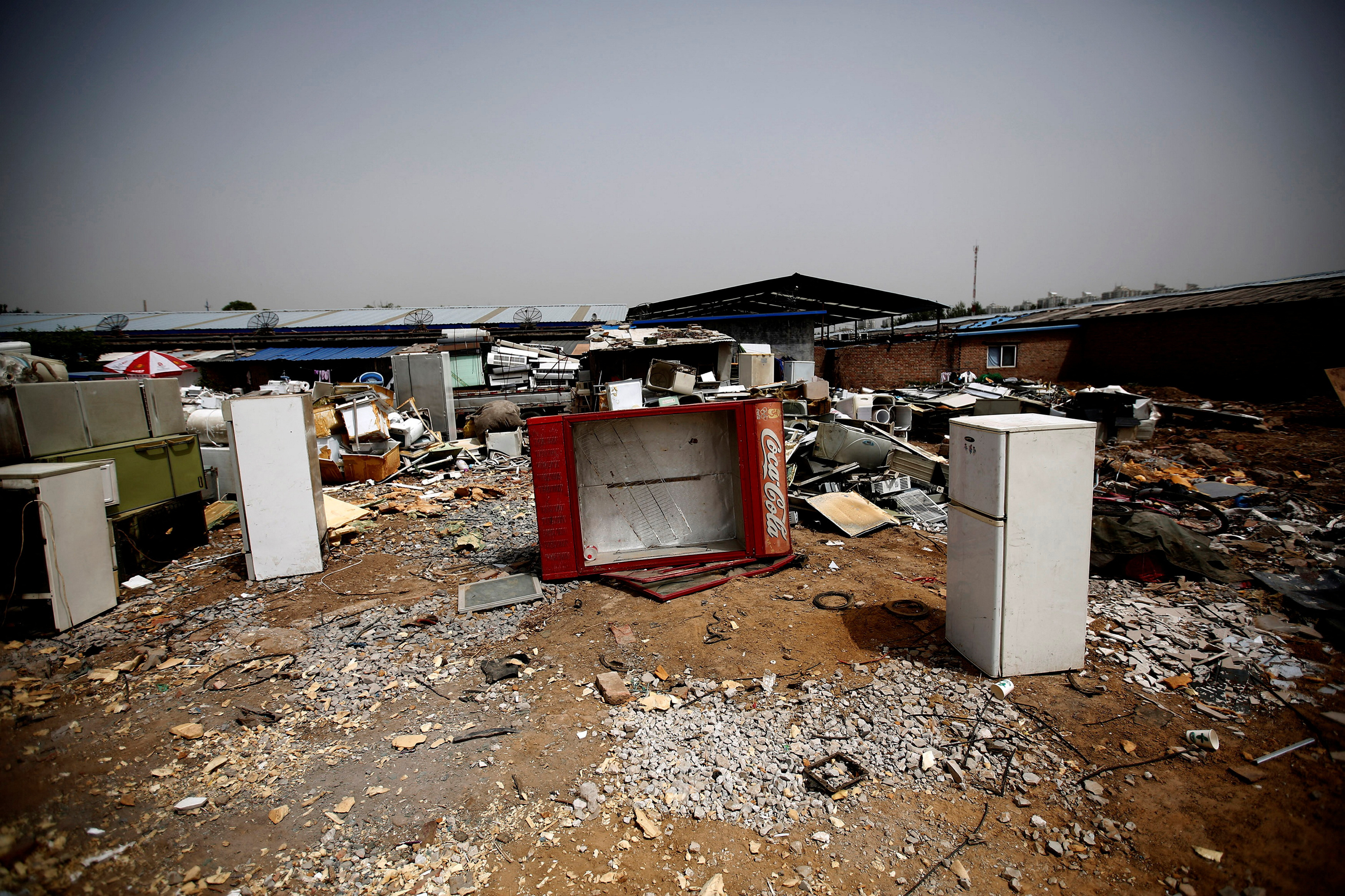 FILE PHOTO: Broken fridges are seen in the yard of a recycling workers' tenement house in Dongxiaokou village in Beijing