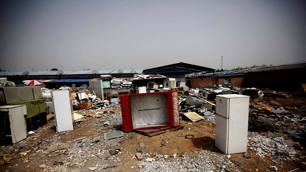 FILE PHOTO: Broken fridges are seen in the yard of a recycling workers' tenement house in Dongxiaokou village in Beijing