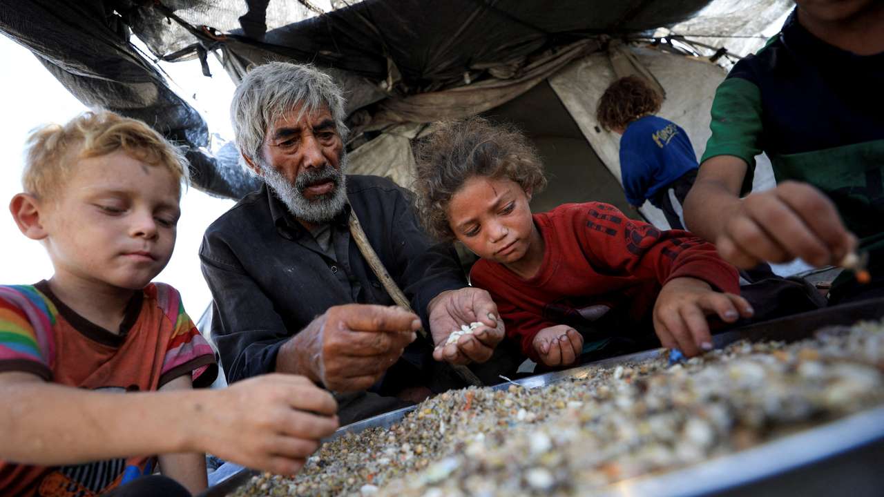 Displaced Palestinians who have not received humanitarian aid survive on leftover food, in Gaza