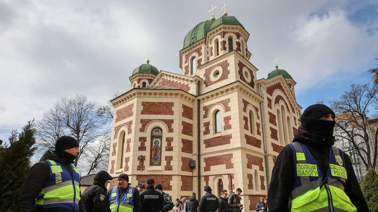 Ukrainian police officers stand next to St. George's Cathedral of the Ukrainian Orthodox Church, accused of being linked to Moscow in Lviv