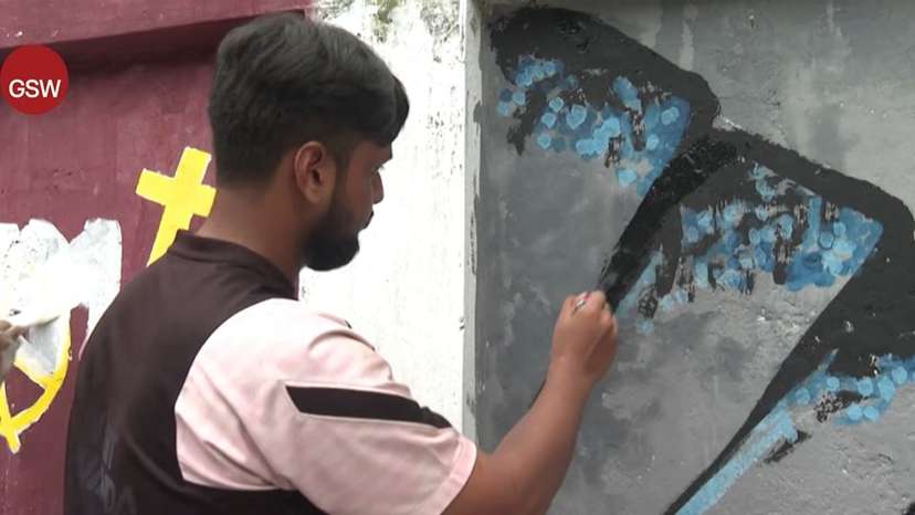 A student paints a wall in the capital of Bangladesh, Dhaka
