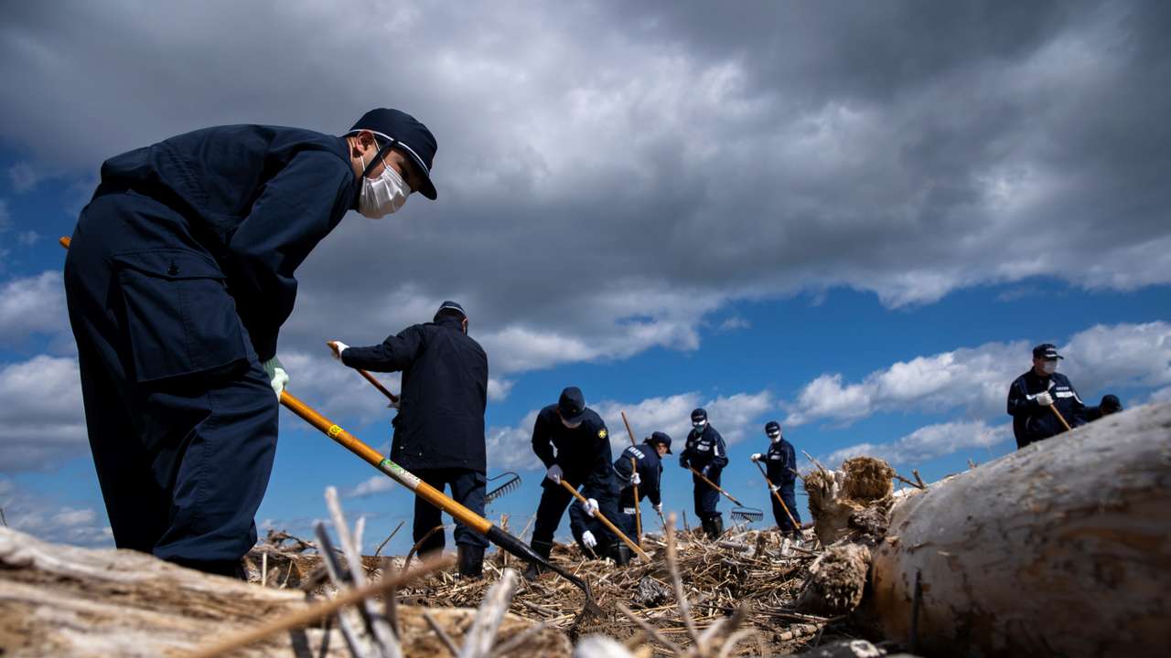 Police officers take part in a search operation for the remains of people who went missing after the March 11, 2011 earthquake and tsunami disaster in Namie, Fukushima prefecture