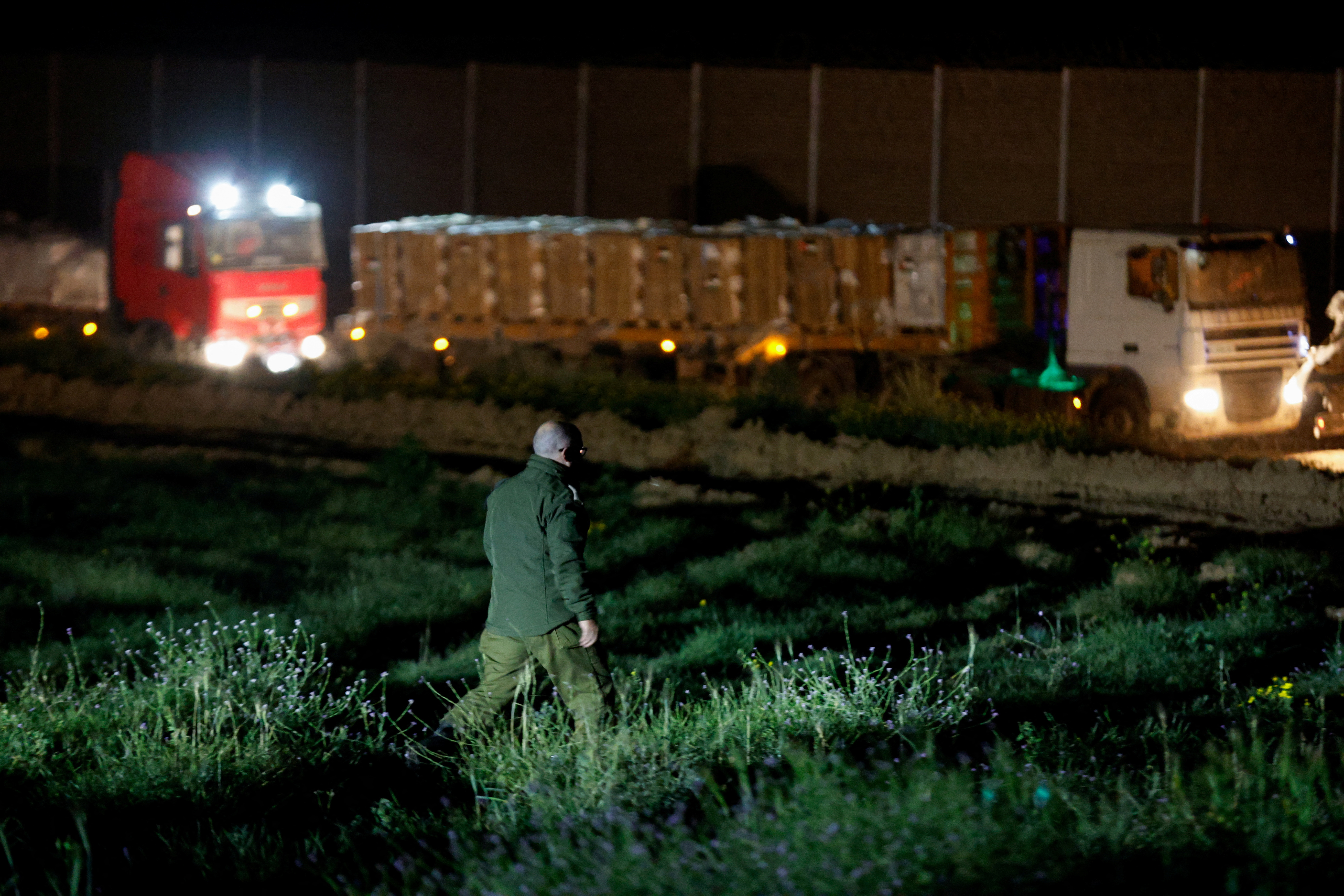 Aid trucks carrying humanitarian supplies into Gaza wait by Gate 96, on Israel-Gaza border
