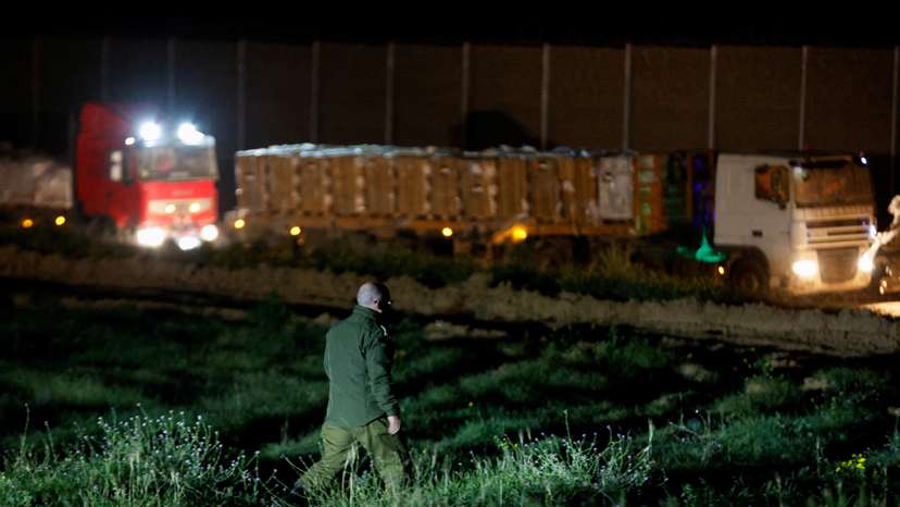 Aid trucks carrying humanitarian supplies into Gaza wait by Gate 96, on Israel-Gaza border