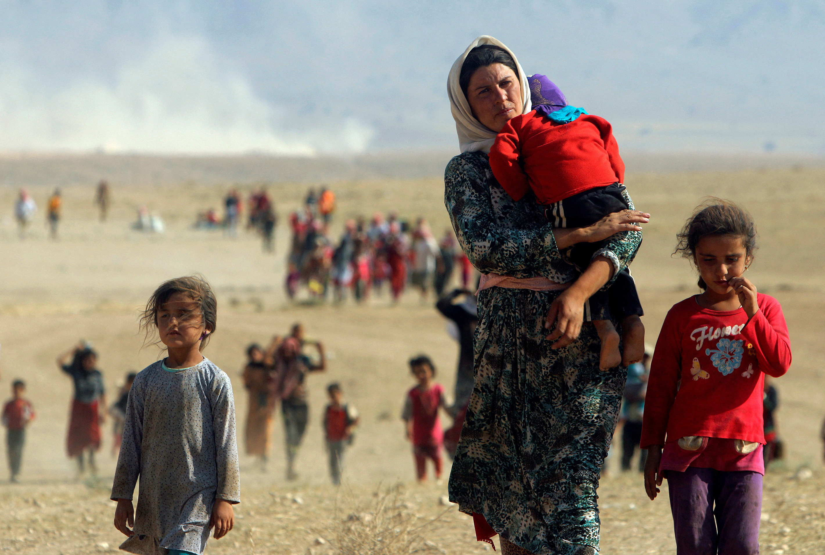 FILE PHOTO: Displaced people from the minority Yazidi sect walk near the Syrian border town of Elierbeh of Al-Hasakah Governorate, Iraq
