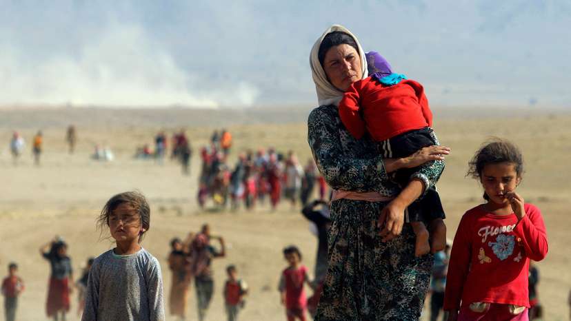 FILE PHOTO: Displaced people from the minority Yazidi sect walk near the Syrian border town of Elierbeh of Al-Hasakah Governorate, Iraq