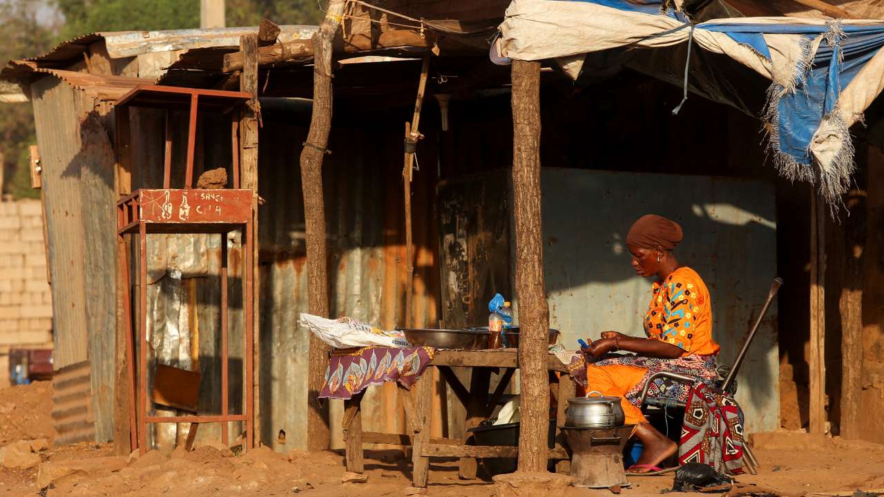 A woman prepares food on the road side in Bamako, Mali