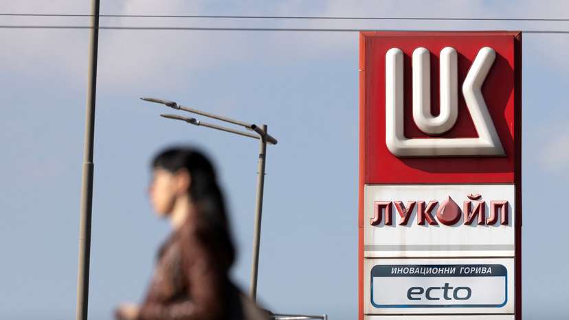 Woman walks near a Lukoil gas station in Sofia