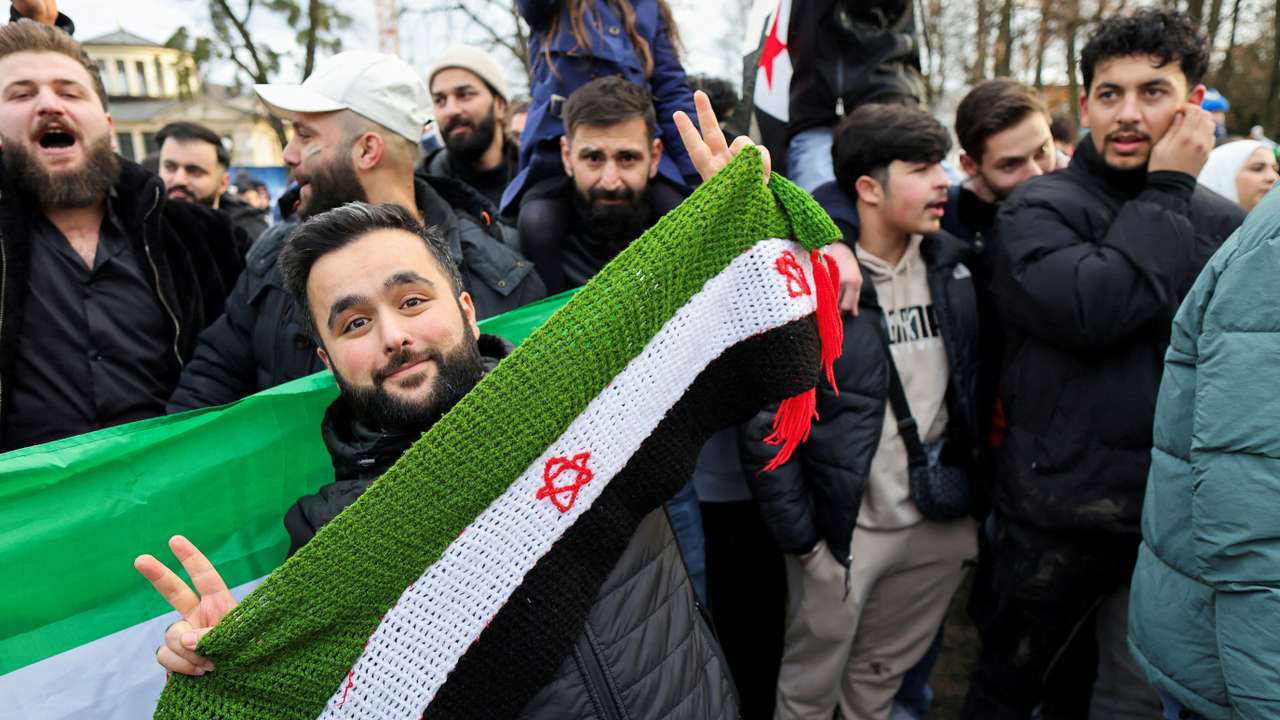 People celebrate in the streets, after Syrian rebels announced that they have ousted Syria's Bashar al-Assad, in Bonn