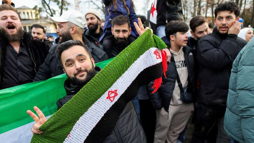 People celebrate in the streets, after Syrian rebels announced that they have ousted Syria's Bashar al-Assad, in Bonn