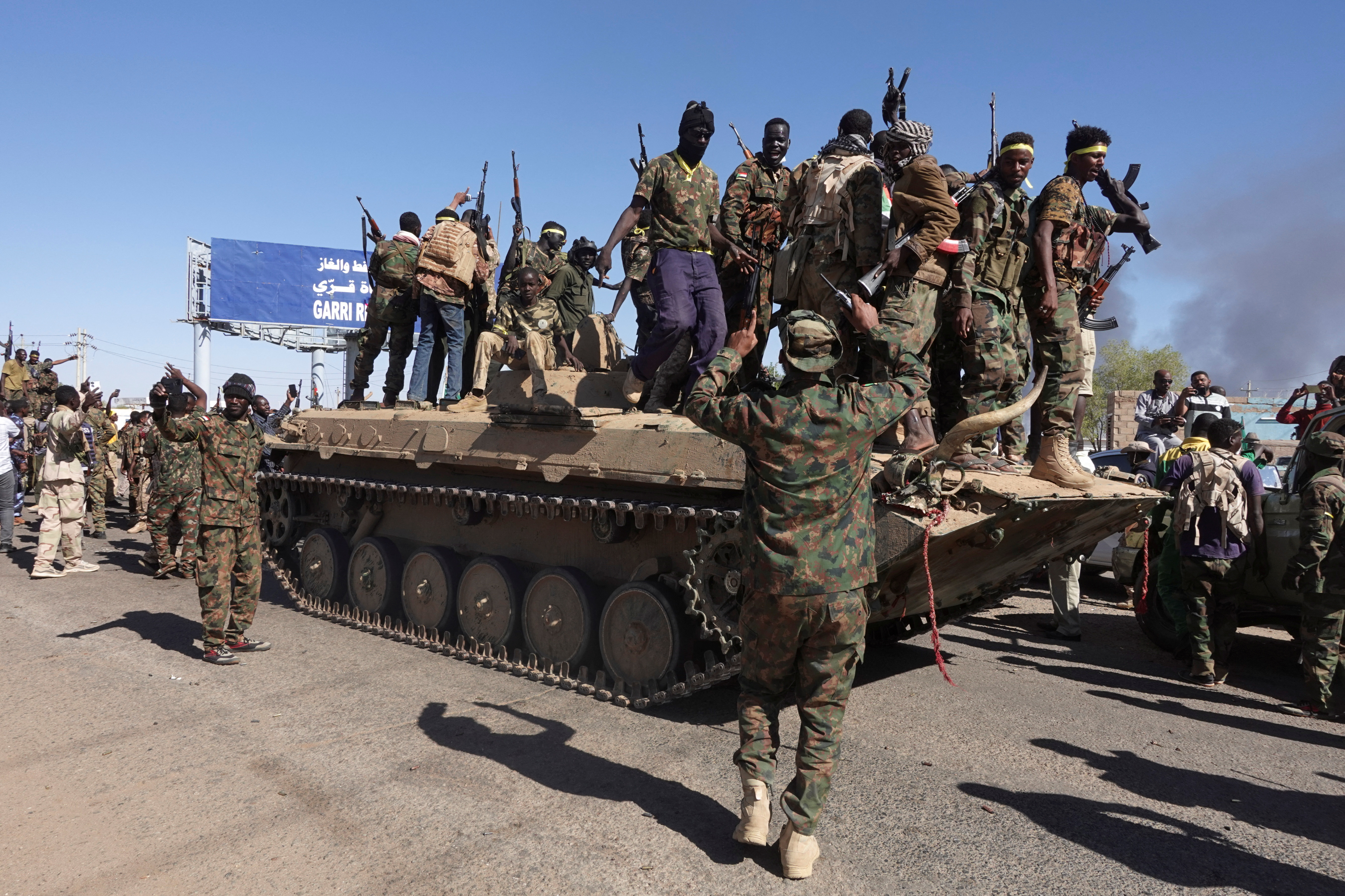 Sudan's army soldiers celebrate the army's liberation of an oil refinery, in North Bahri, Sudan