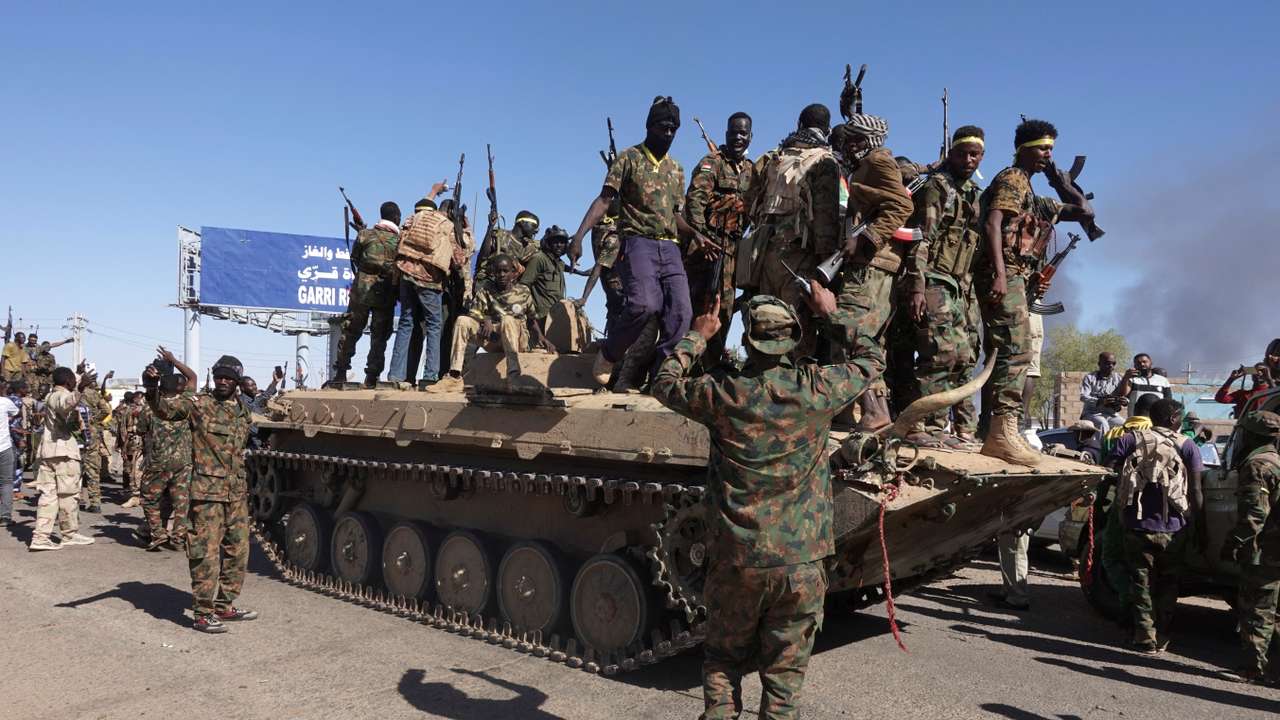 Sudan's army soldiers celebrate the army's liberation of an oil refinery, in North Bahri, Sudan