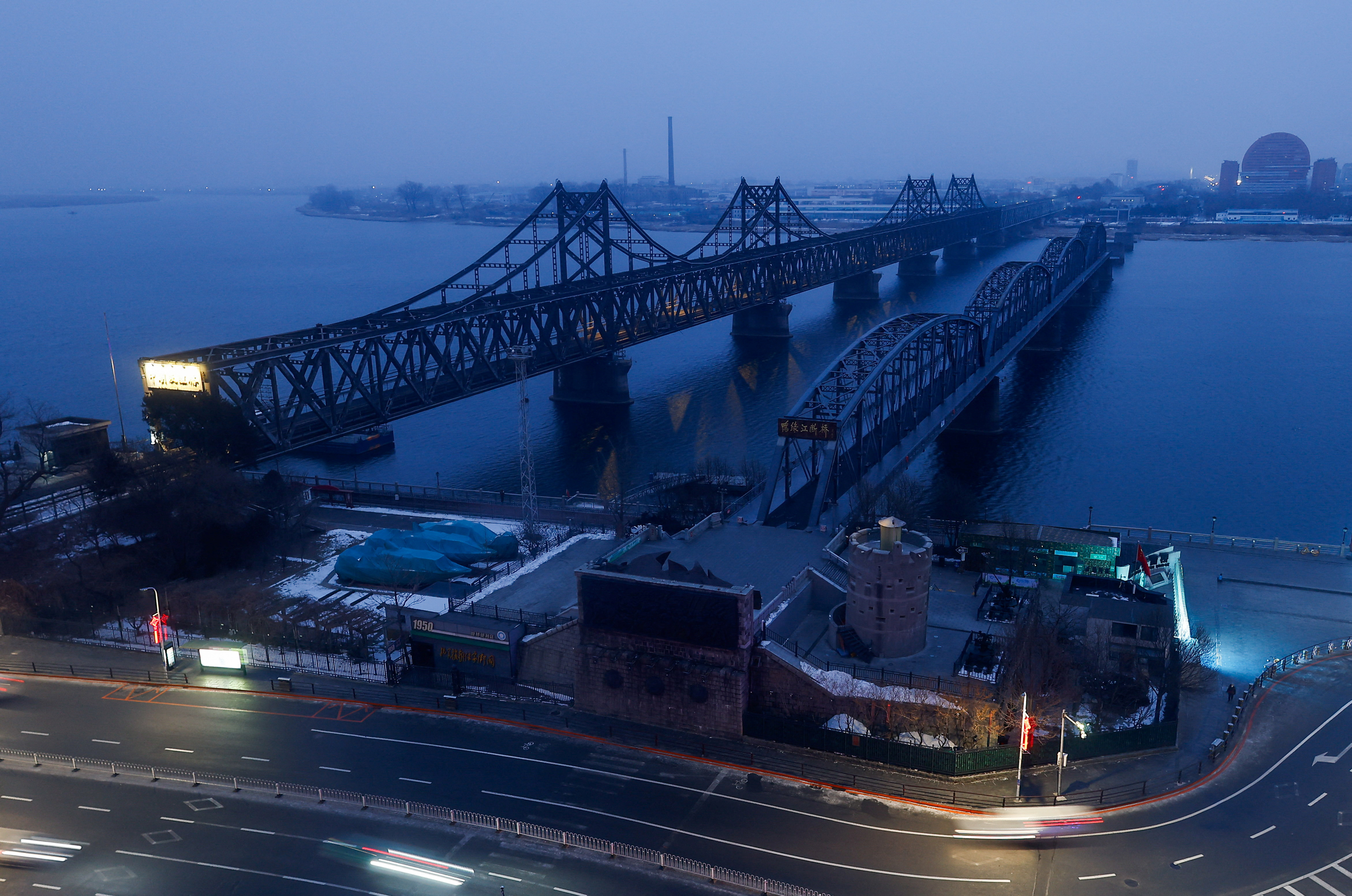 The Friendship Bridge and Broken Bridge over the Yalu River, which separates North Korea's Sinuiju from China, are seen before sunrise in Dandong