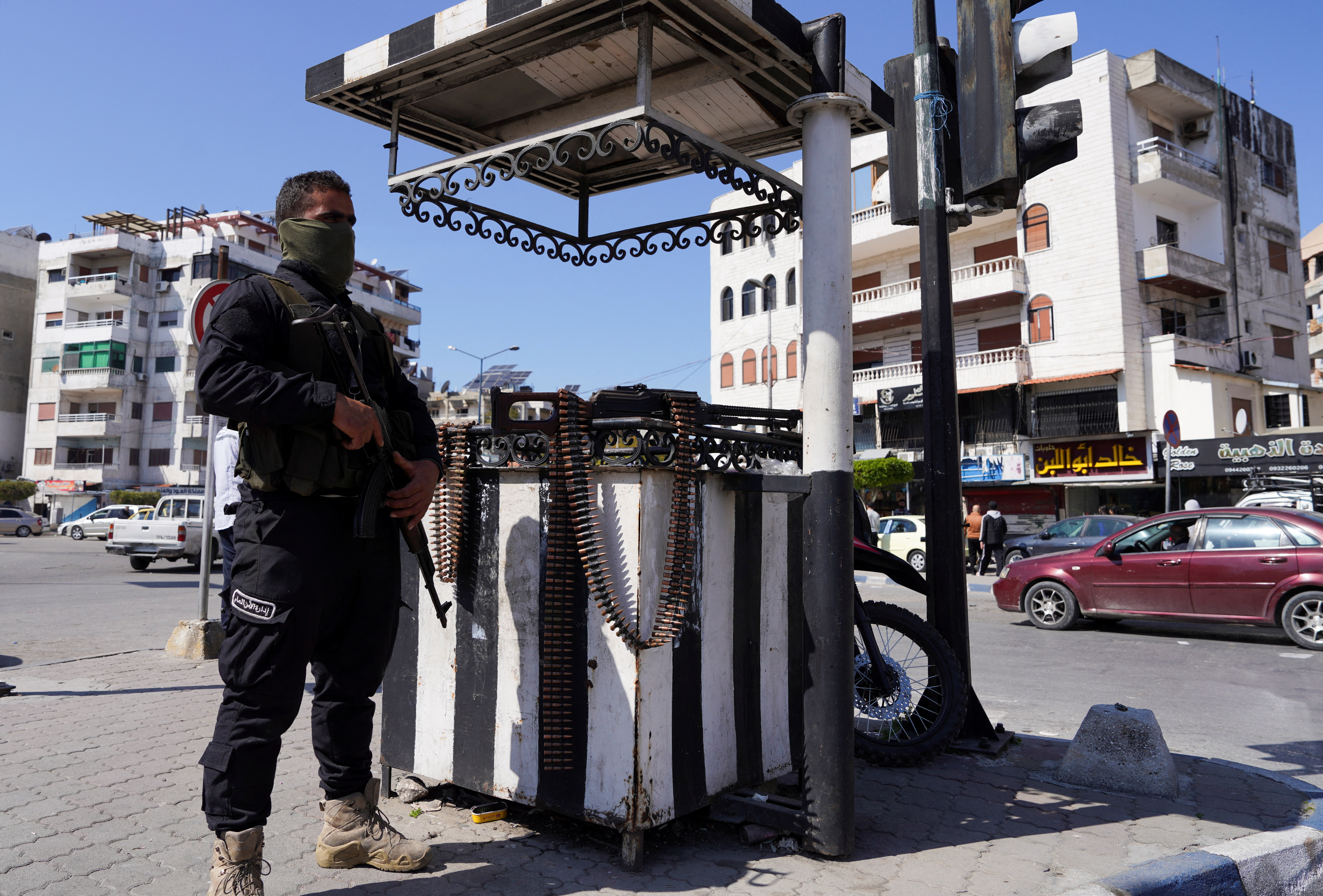 A member of the Syrian security forces stands guard along a street, in Latakia