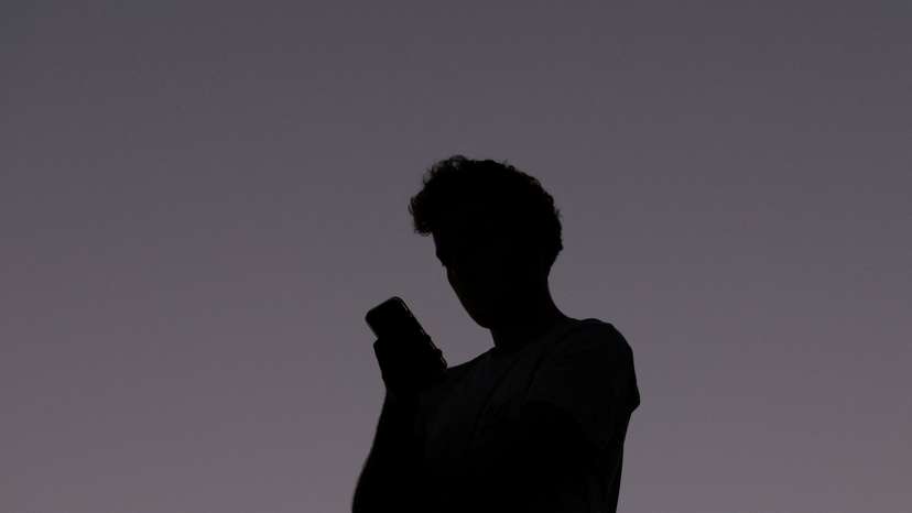 A man uses a mobile phone at dusk in Brisbane