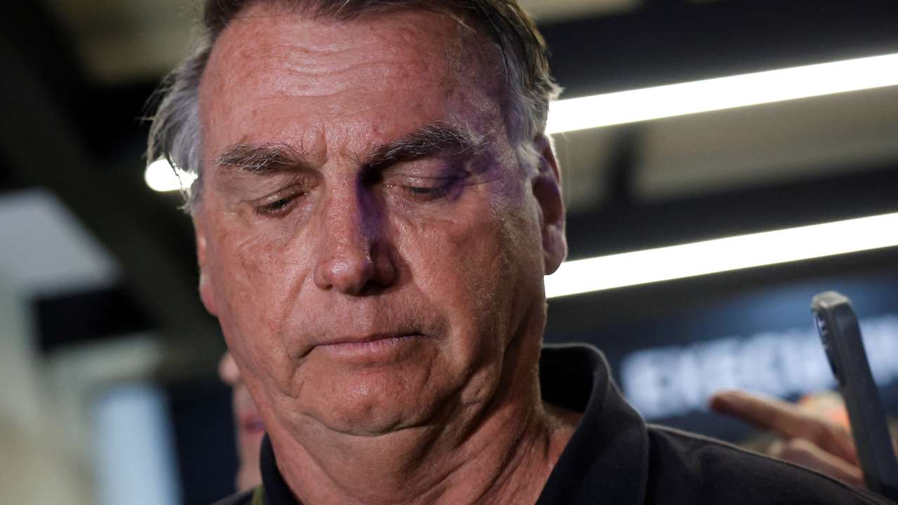 Brazil's former President Jair Bolsonaro talks with media upon his arrival at Brasilia International Airport