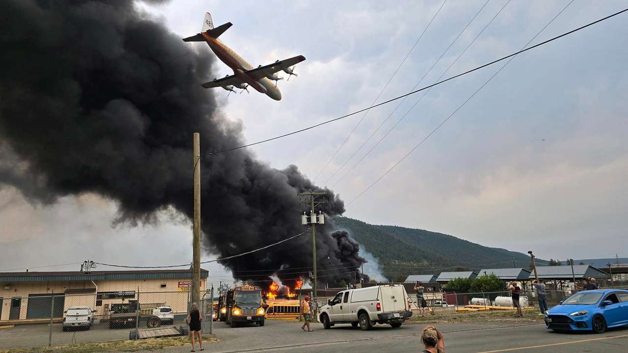 An air tanker flies low over a wildfire burning on the edge of the Cariboo region city of Williams Lake
