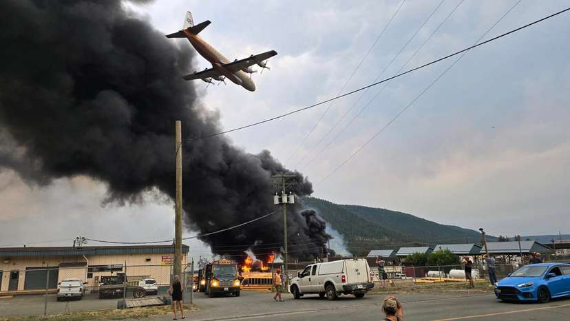 An air tanker flies low over a wildfire burning on the edge of the Cariboo region city of Williams Lake