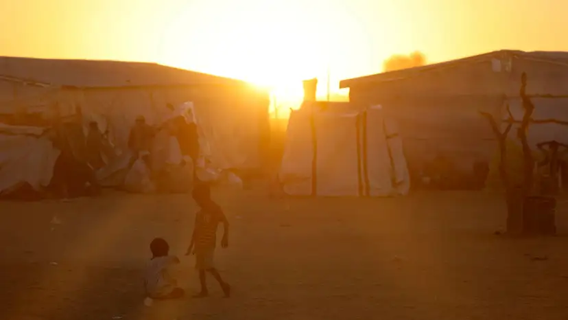 Sudanese refugee children from al-Fashir play during the sunset over the Tine transit refugee camp