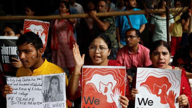 Doctors hold signs as they attend a protest condemning the rape and murder of a trainee doctor, inside the premises of R. G. Kar Medical College and Hospital in Kolkata