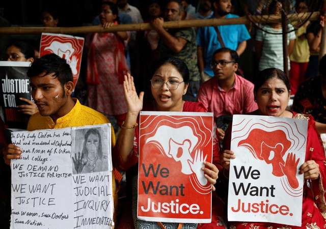 Doctors hold signs as they attend a protest condemning the rape and murder of a trainee doctor, inside the premises of R. G. Kar Medical College and Hospital in Kolkata