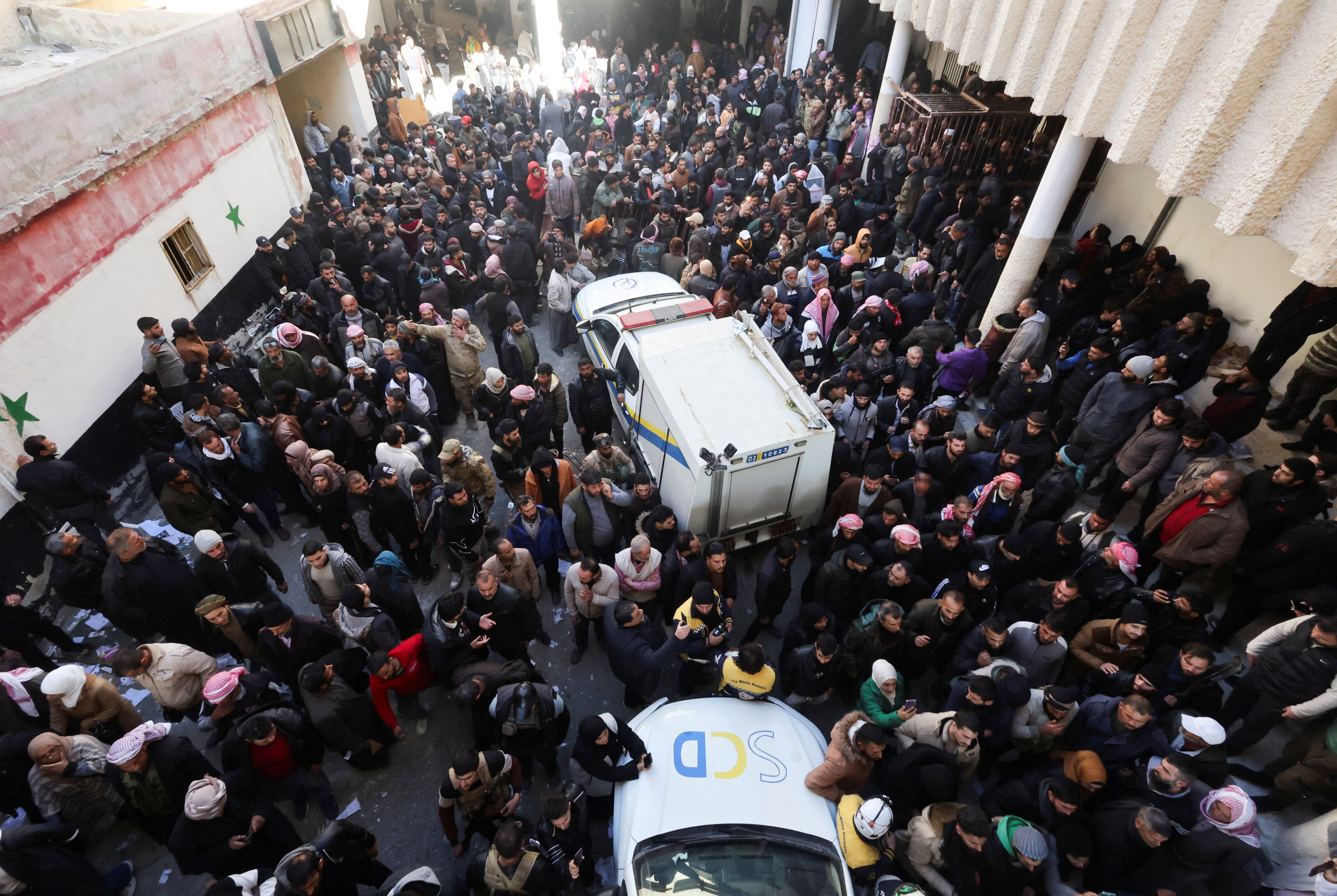 Members of the Syrian civil defence group search Sednaya prison