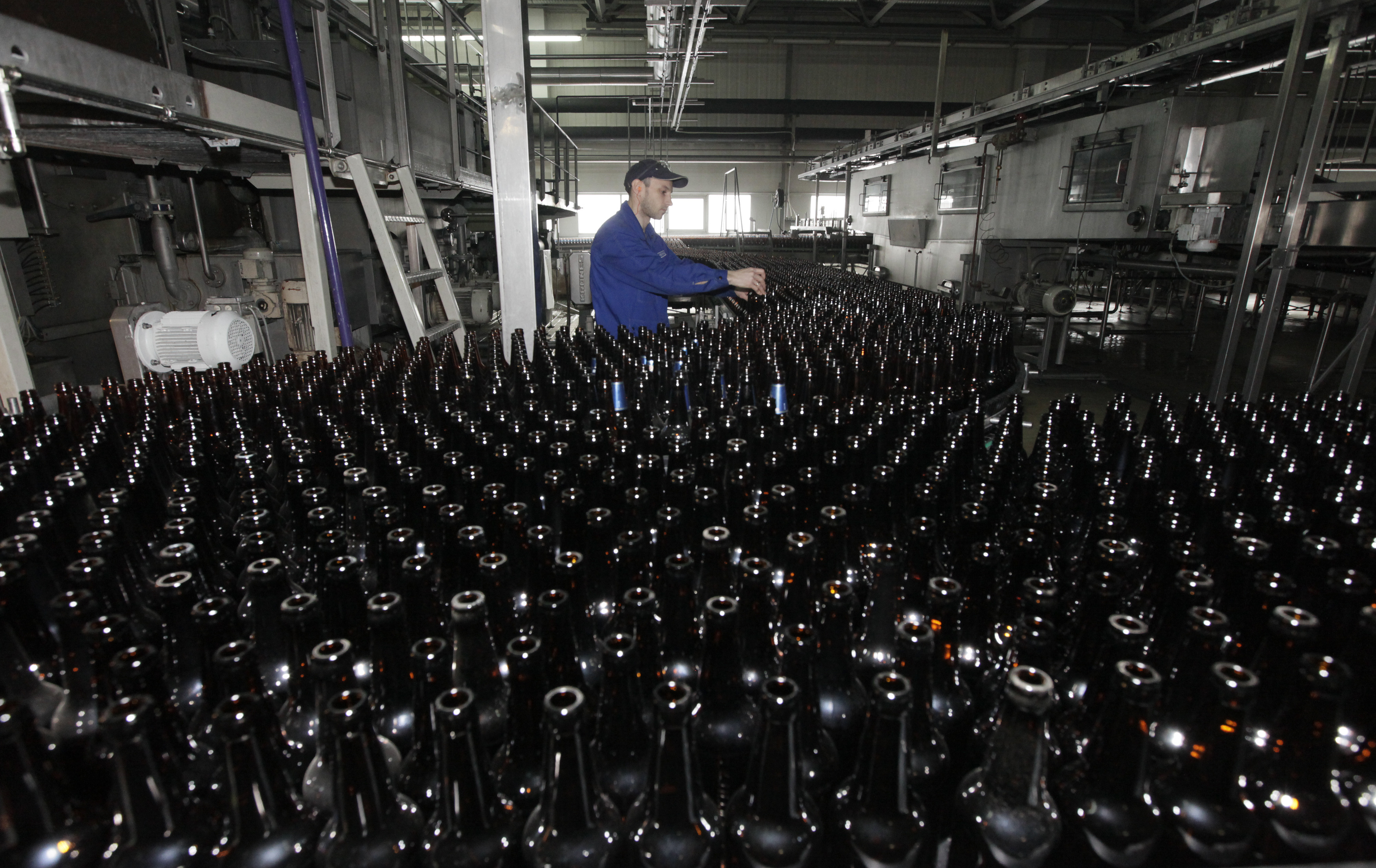 FILE PHOTO: An employee works at a line bottling beer at Carlsberg brewery "Baltika-Pikra" factory in Krasnoyarsk