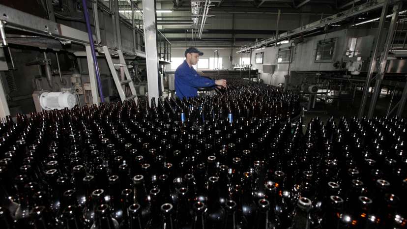 FILE PHOTO: An employee works at a line bottling beer at Carlsberg brewery "Baltika-Pikra" factory in Krasnoyarsk