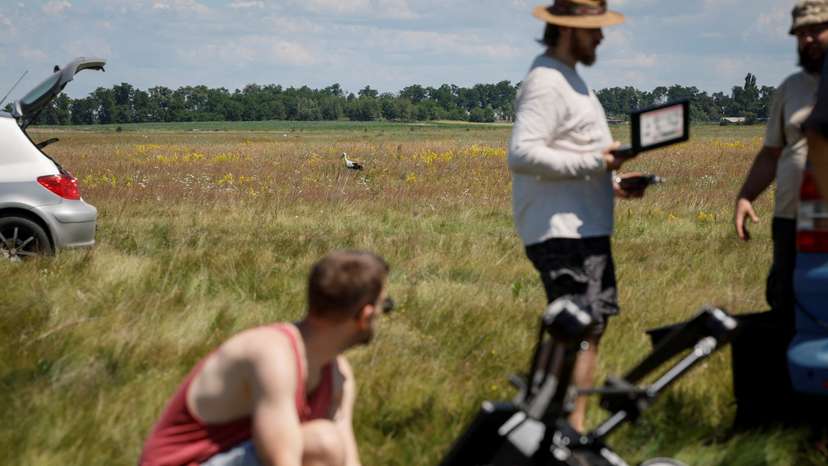 A stork walks across a field as employees of Swarmer company prepare the AI-enabled drone for flight in Kyiv region