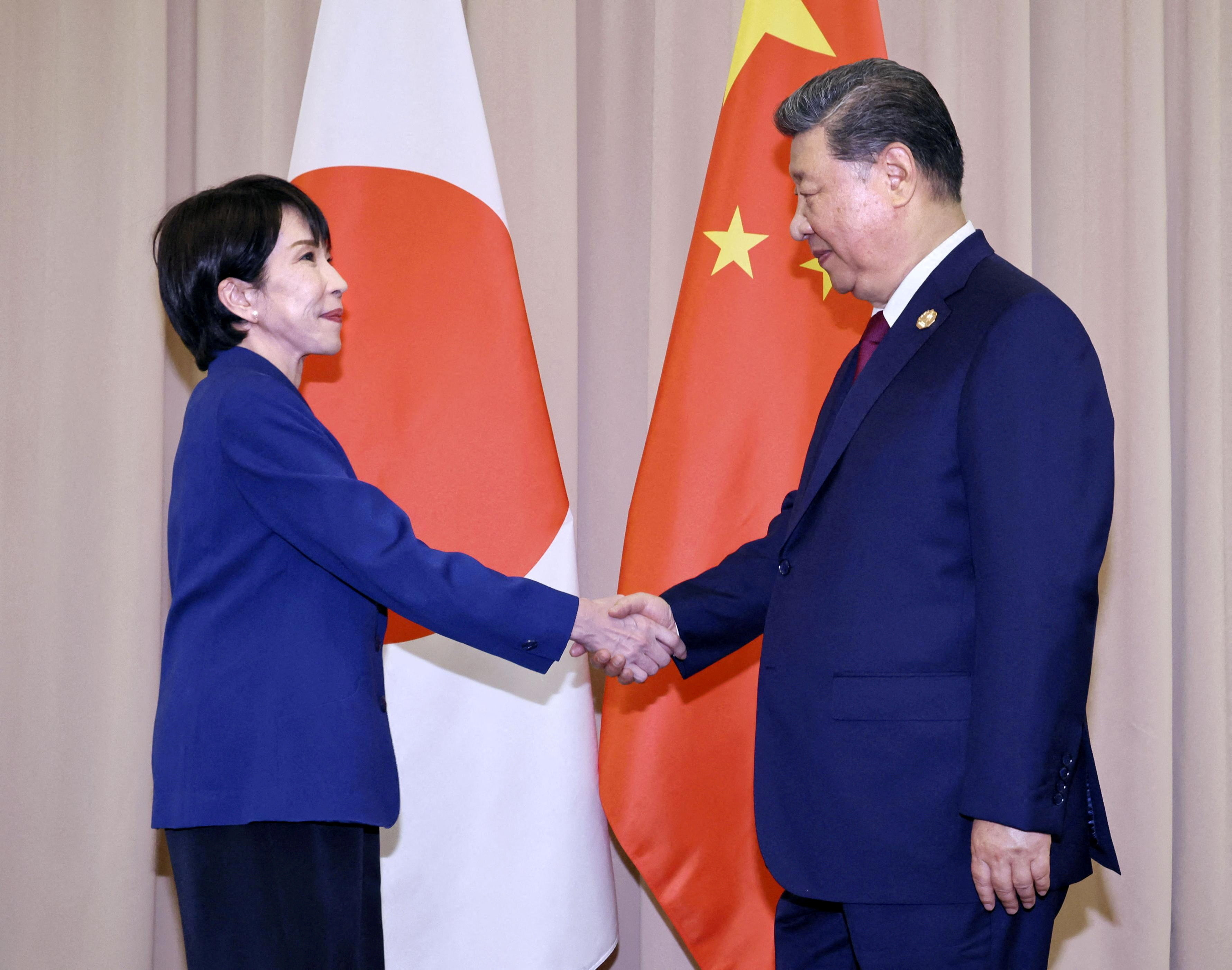 FILE PHOTO: Japanese Prime Minister Sanae Takaichi shakes hands with Chinese President Xi Jinping ahead of their talks in Gyeongju, South Korea