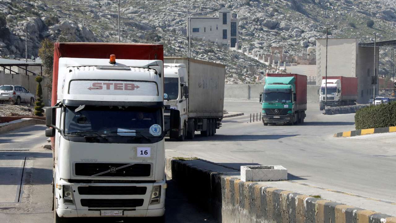 FILE PHOTO: A convoy of trucks carrying aid from UN World Food Programme (WFP) enters Bab al-Hawa crossing